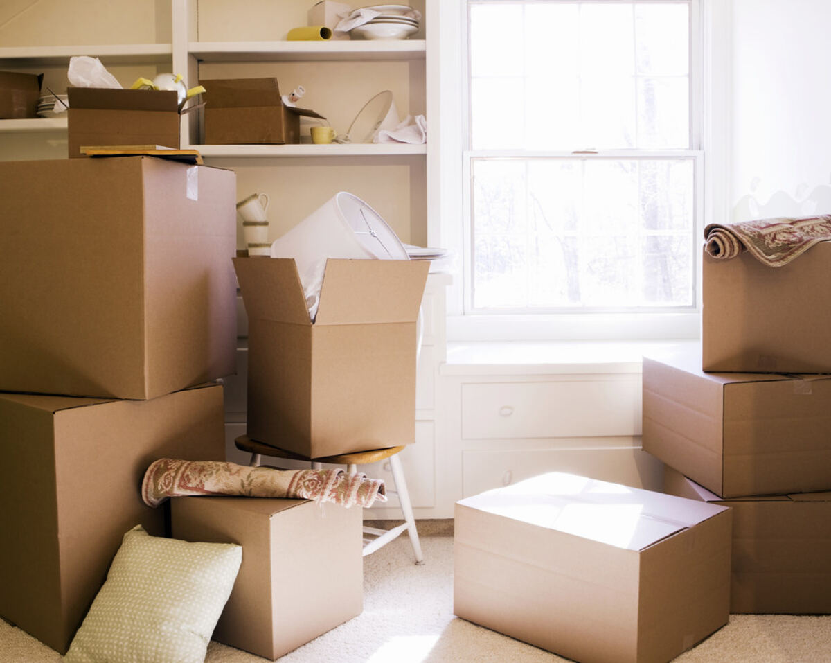 Cajas de cartón apiladas junto a una ventana durante una mudanza