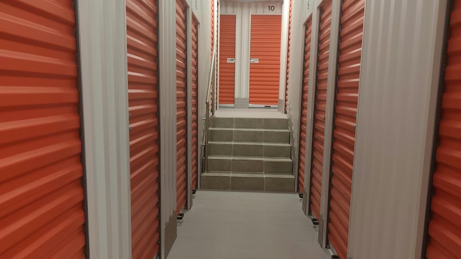 Pasillo de trasteros con puertas naranjas en Burjassot, zona de la Eixereta
